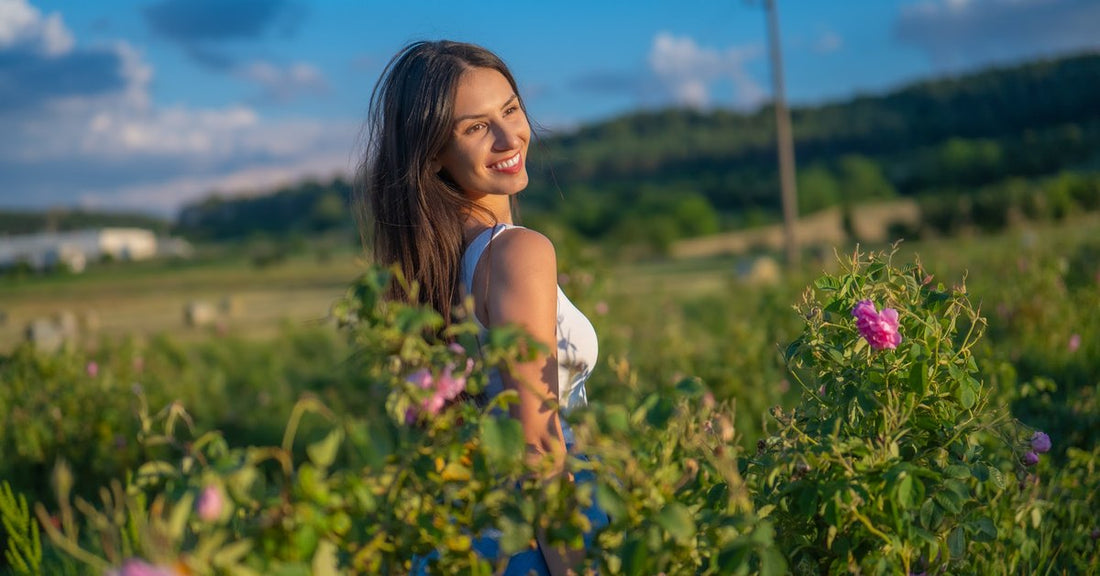 Mulher num campo de rosas em flor no Vale das Rosas búlgaro